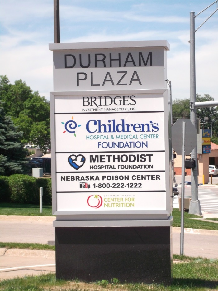 Illuminated, double-face Durham Plaza tenant monument sign at 84th and Dodge